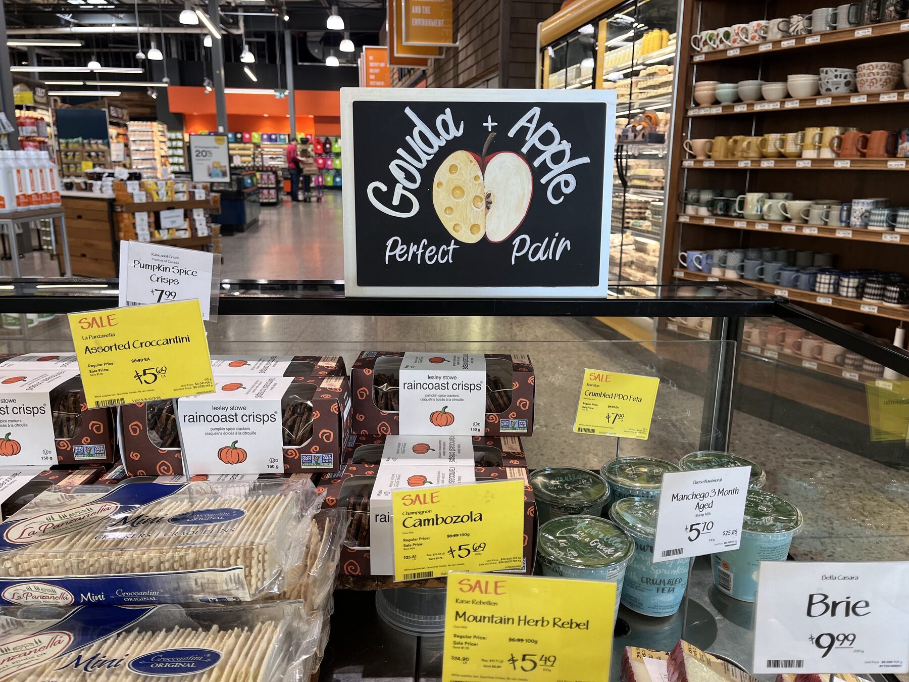 Gouda and apple display with illustrated chalkboard in store context