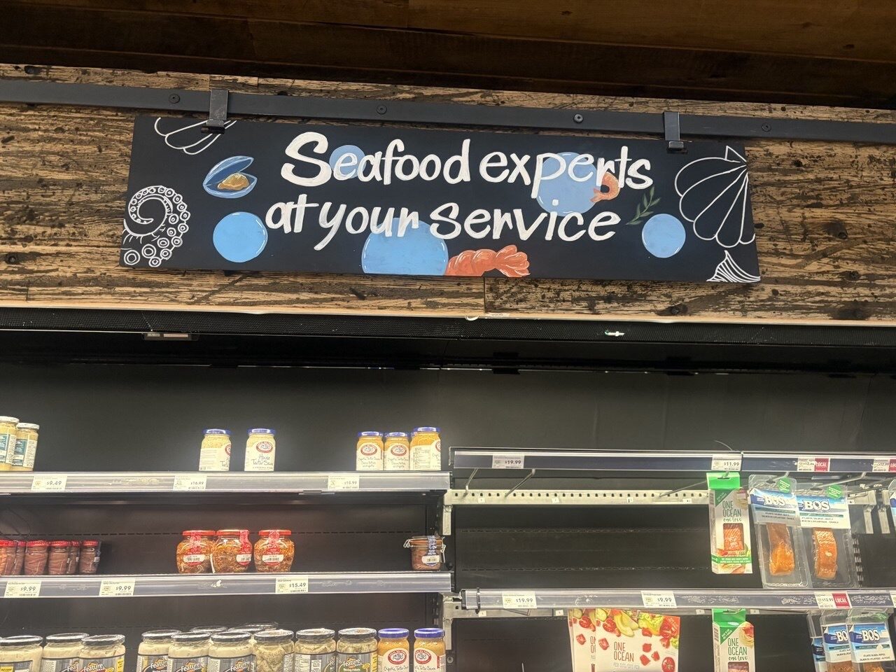 Seafood experts at your service retail sign